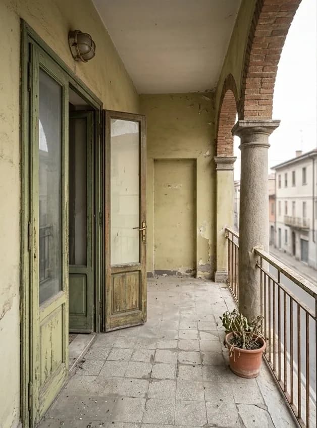 Before: an arched balcony with flaking paint, damaged timber doors and broken floor tiles.